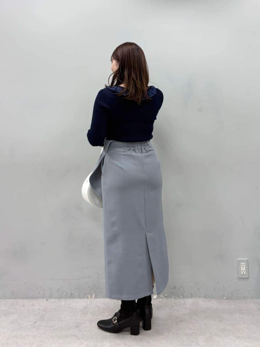 ブルー系のニット/セーター、グレー系のスカートを着用したレディースの冬コーディネートの3枚目の写真