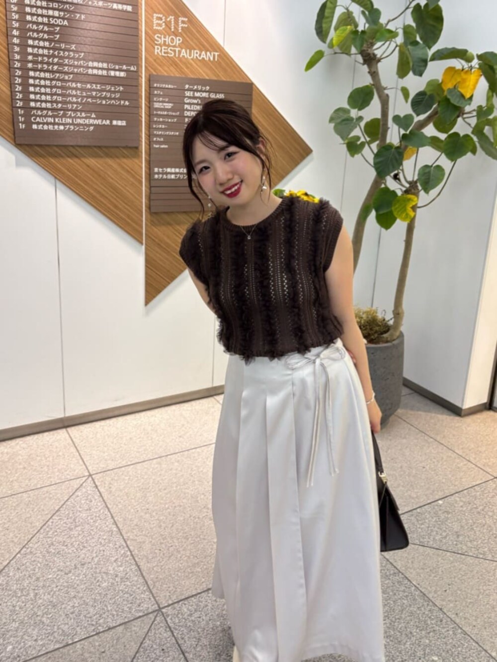 ブラウン系のニット/セーターを着用したレディースの夏コーディネートの3枚目の写真