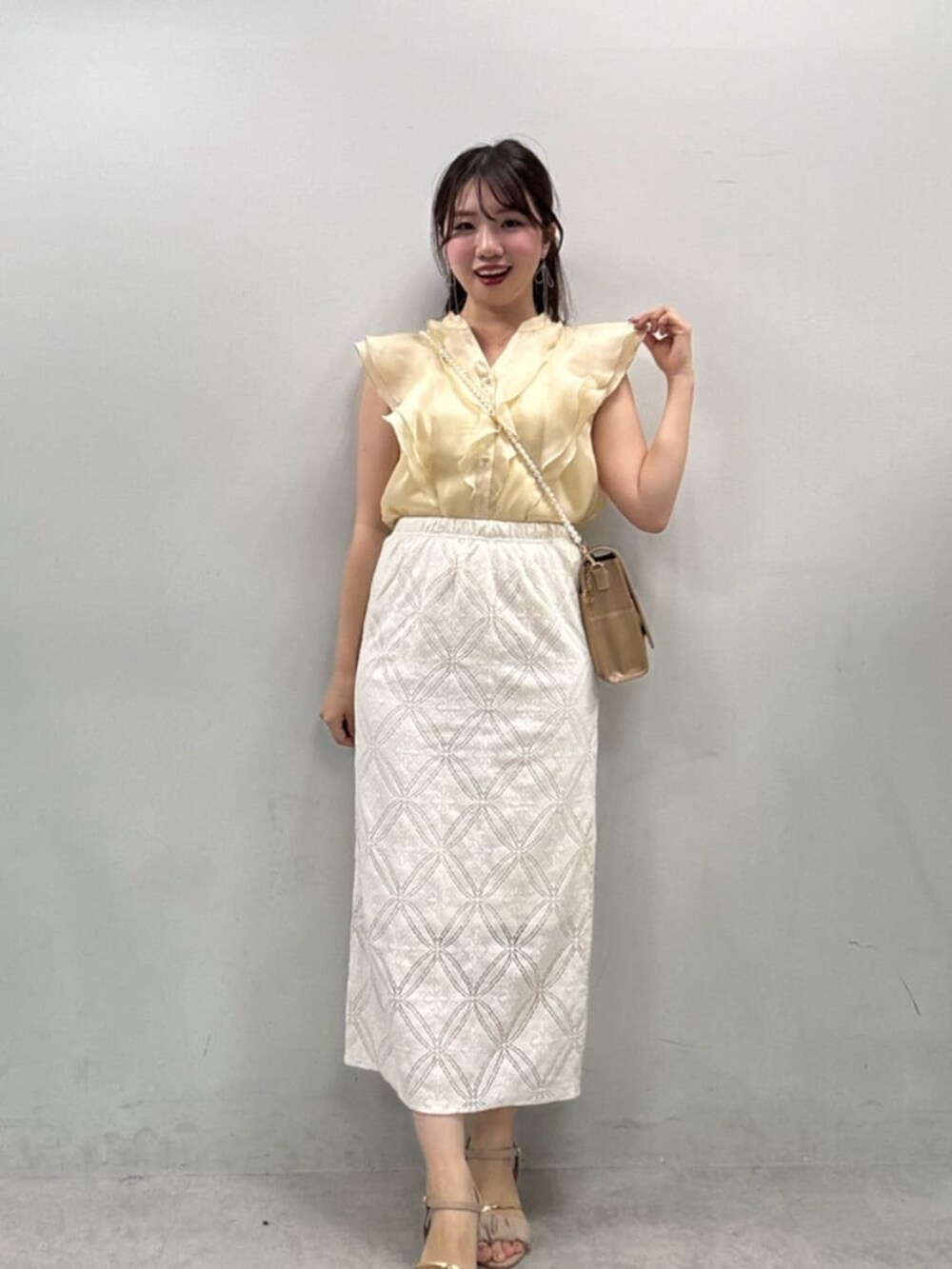 ベージュ系のシャツ/ブラウス、ホワイト系のスカートを着用したレディースの夏コーディネートの2枚目の写真