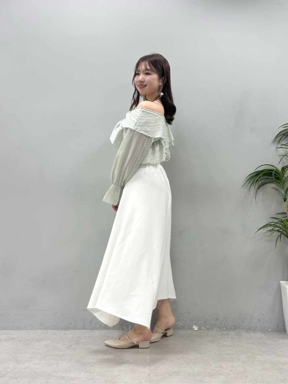 グリーン系のシャツ/ブラウス、ホワイト系のスカートを着用したレディースの春コーディネートの3枚目の写真