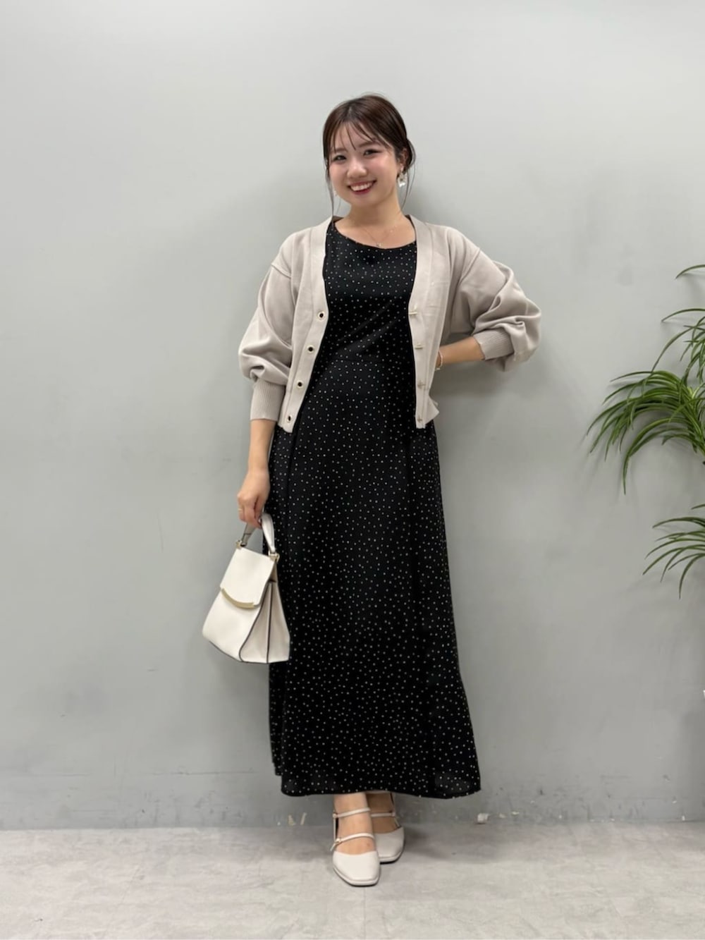ブラック系のワンピース、ベージュ系のカーディガン/ボレロを着用したレディースの夏コーディネートの2枚目の写真