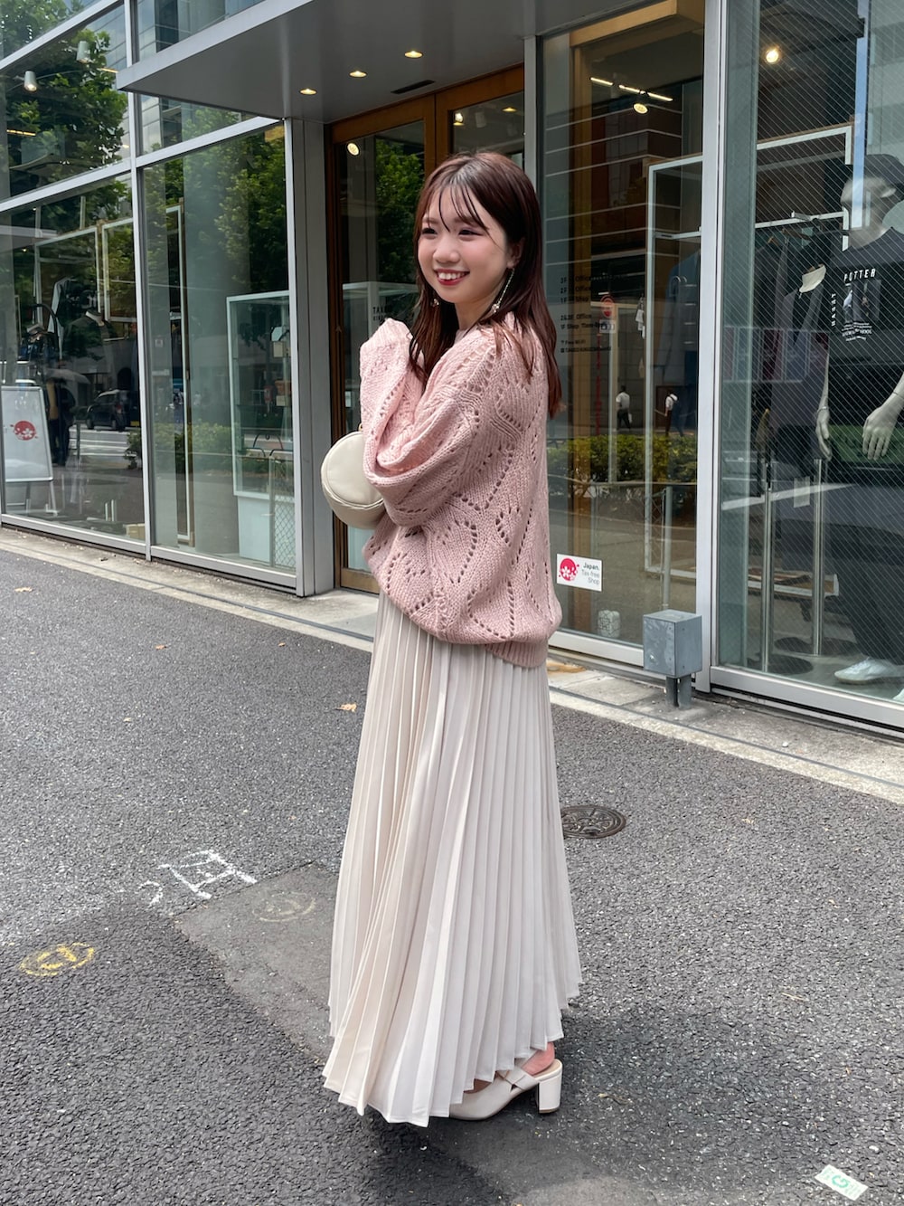 ピンク系のニット/セーター、ベージュ系のスカートを着用したレディースの夏コーディネートの2枚目の写真