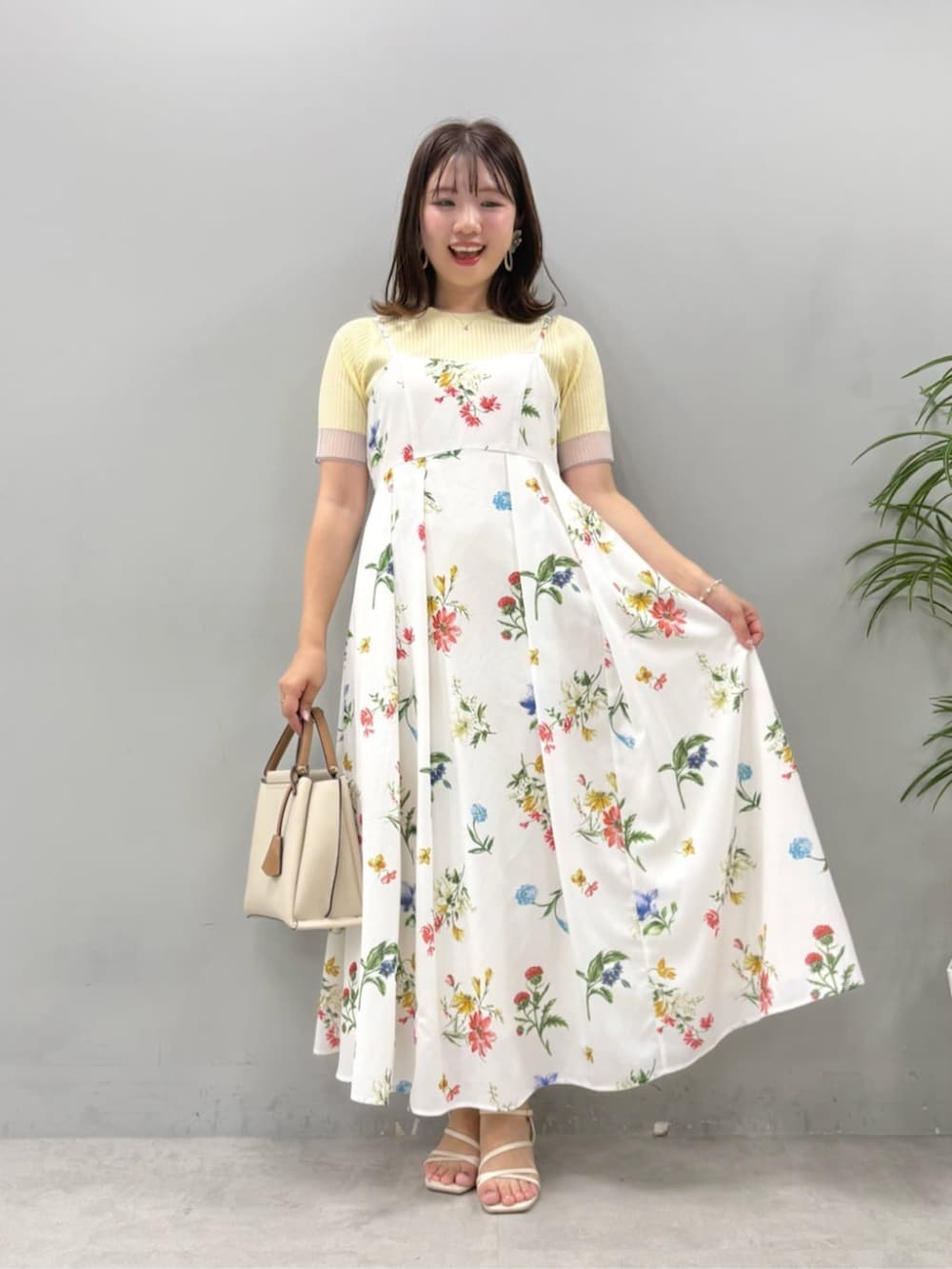 イエロー系のニット/セーター、ホワイト系のワンピースを着用したレディースの夏コーディネートの4枚目の写真