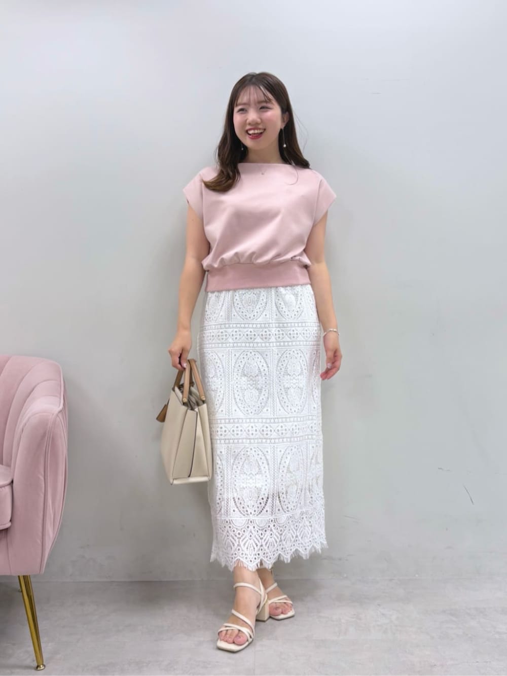 ホワイト系のスカート、ピンク系のタンクトップを着用したレディースの夏コーディネートの2枚目の写真