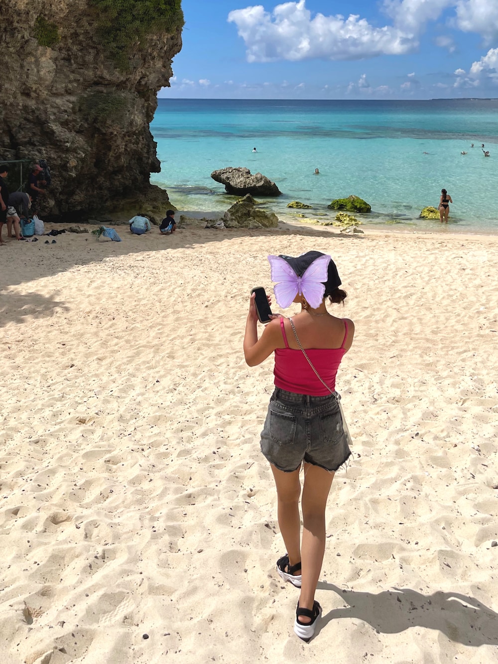 ピンク系のキャミソール、シルバー系のショルダーバッグ、ブルー系のデニムパンツを着用したレディースの秋コーディネートの2枚目の写真