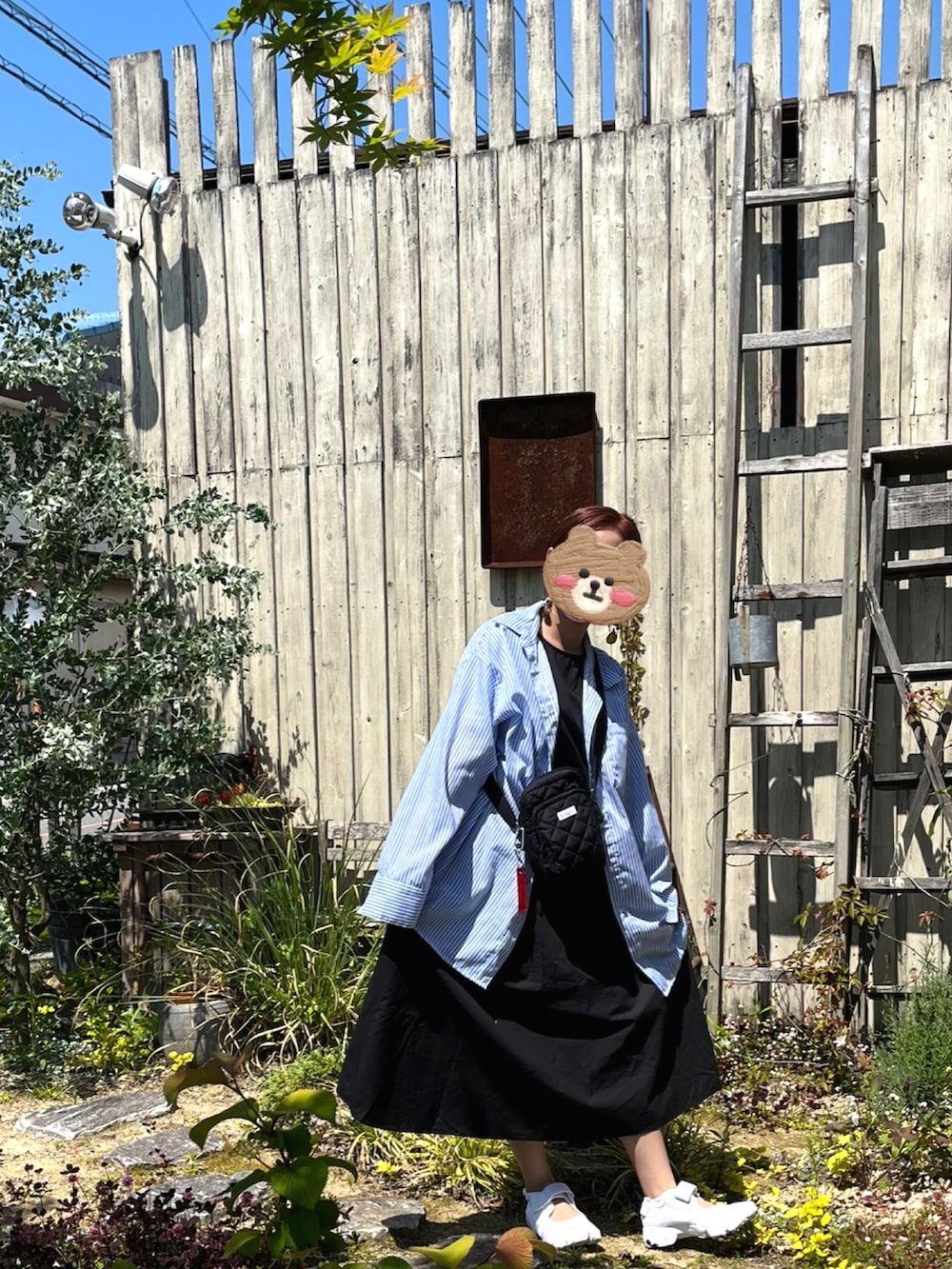 ブルー系のシャツ/ブラウス、ブラック系のワンピース、ホワイト系のスニーカーを着用したレディースの春コーディネートの3枚目の写真