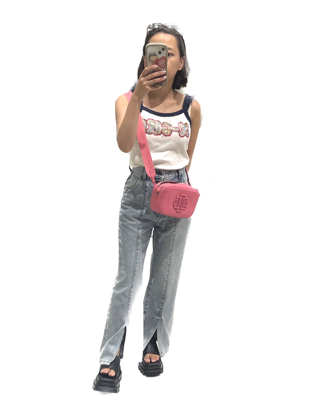 ブラック系のサンダル、ホワイト系のキャミソール、ピンク系のバッグを着用したレディースの夏コーディネートの2枚目の写真