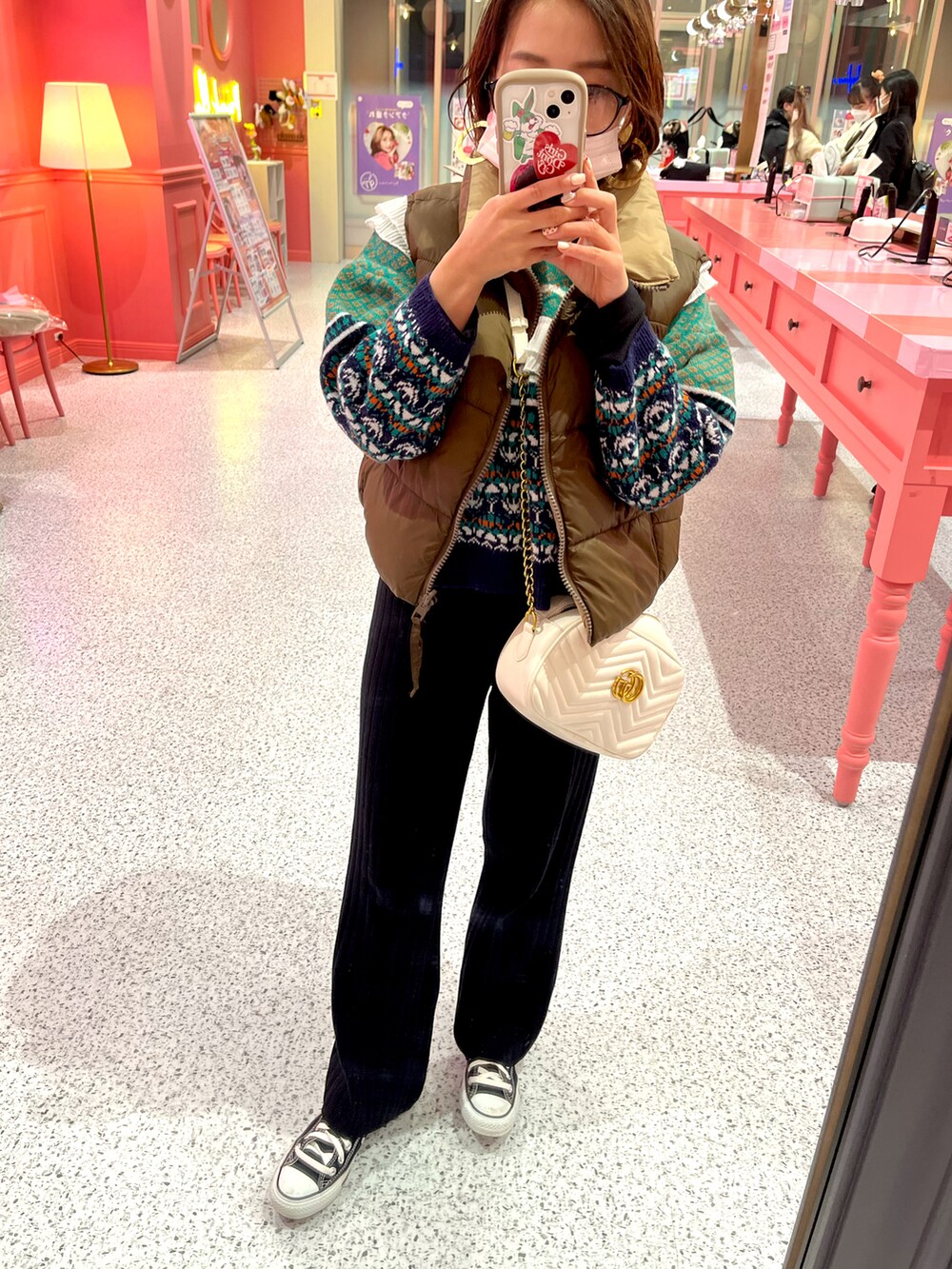 ブラック系のスニーカー、ブラック系のその他パンツ、ブラウン系のダウンベストを着用したレディースの冬コーディネートの2枚目の写真