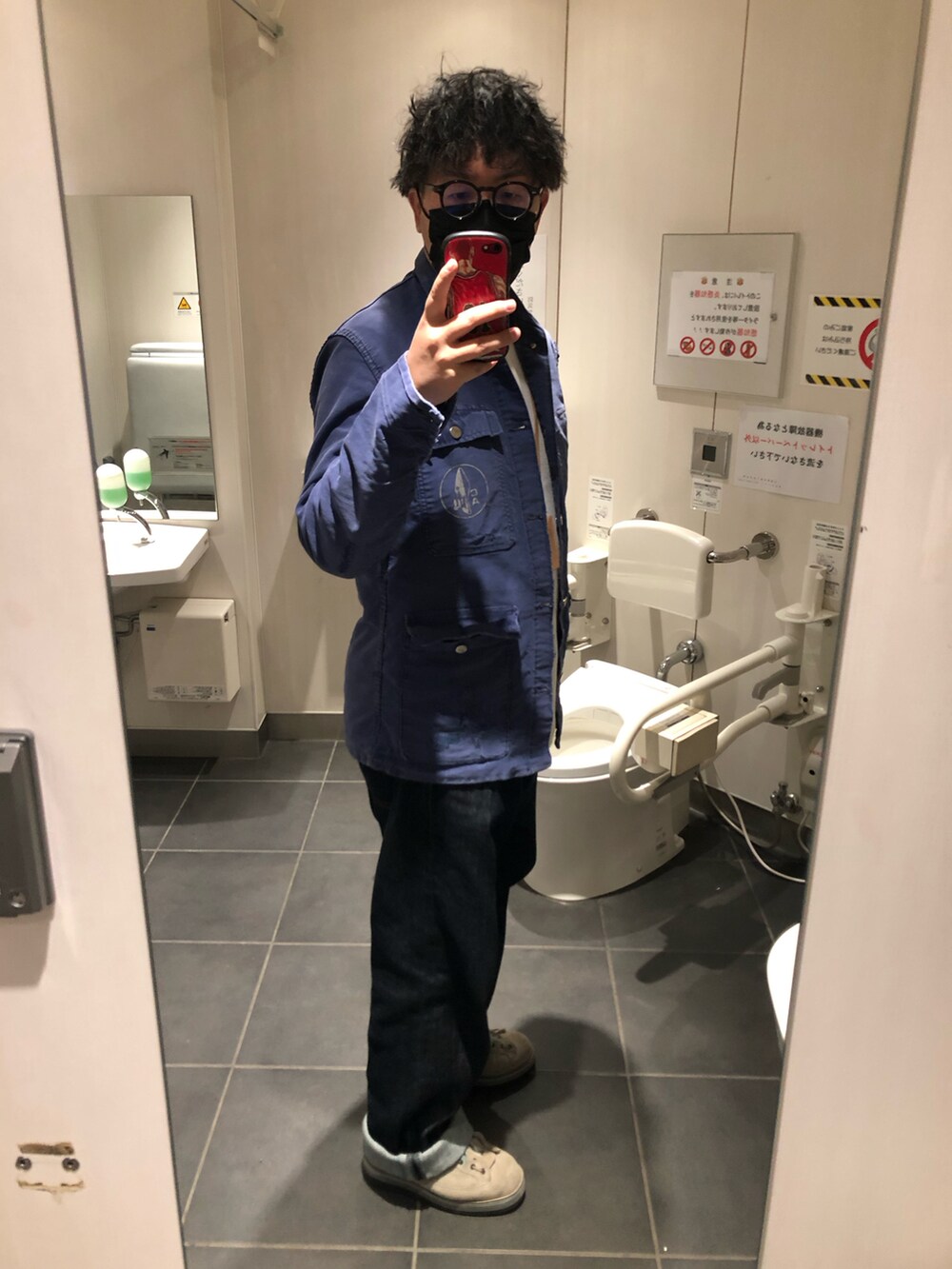 グレー系のミリタリージャケット、ブルー系のデニムパンツ、グレー系のブーツを着用したメンズの冬コーディネートの3枚目の写真