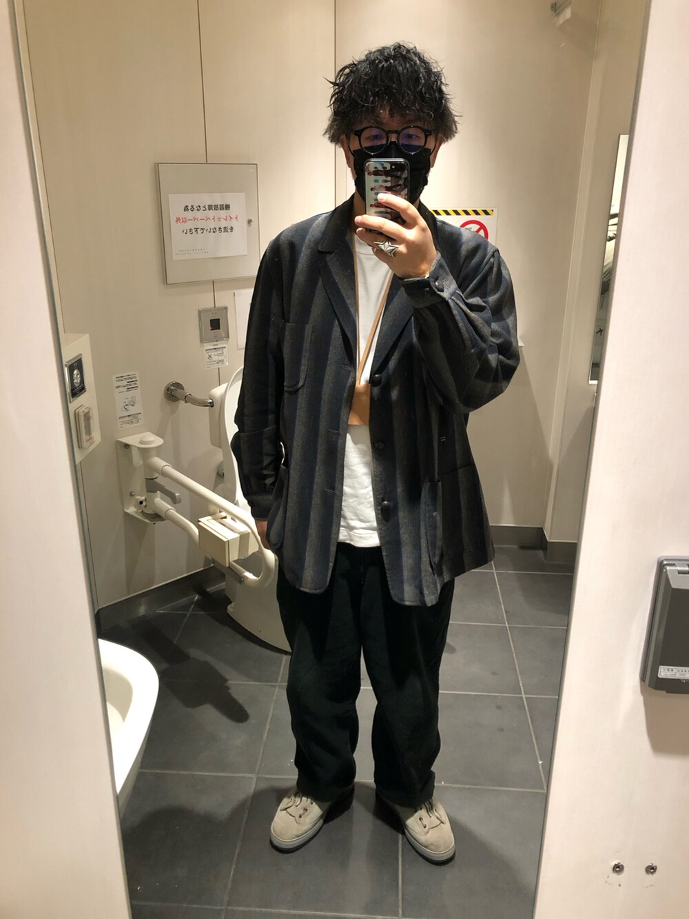 グレー系のミリタリージャケット、グリーン系のスラックス、グレー系のブーツを着用したメンズの春コーディネートの2枚目の写真