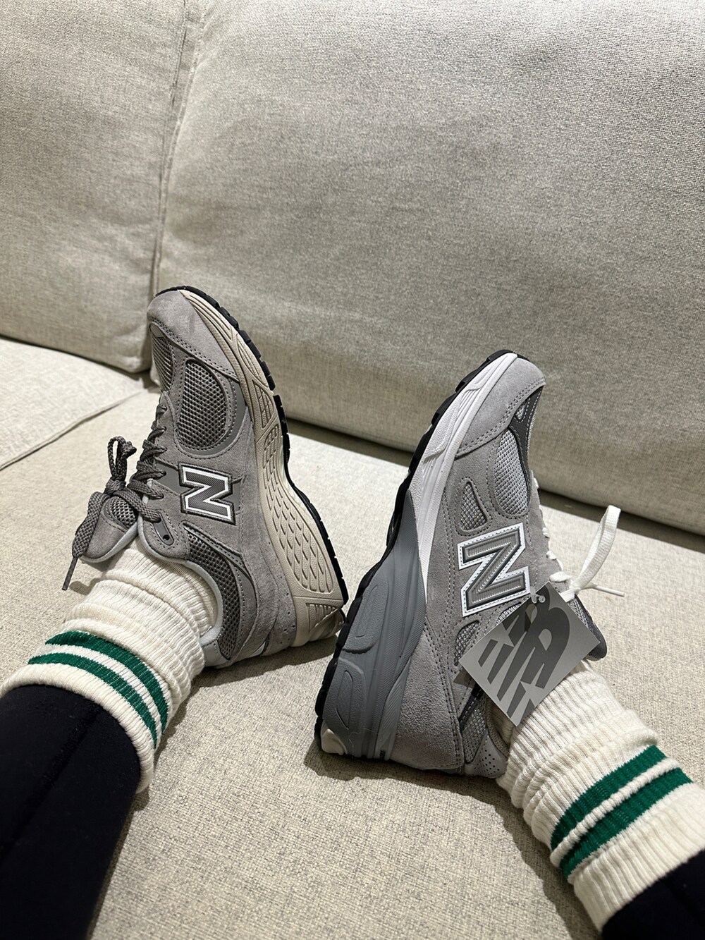 グレー系のスニーカー、ホワイト系のレッグウェアを着用したレディースの冬コーディネートの2枚目の写真