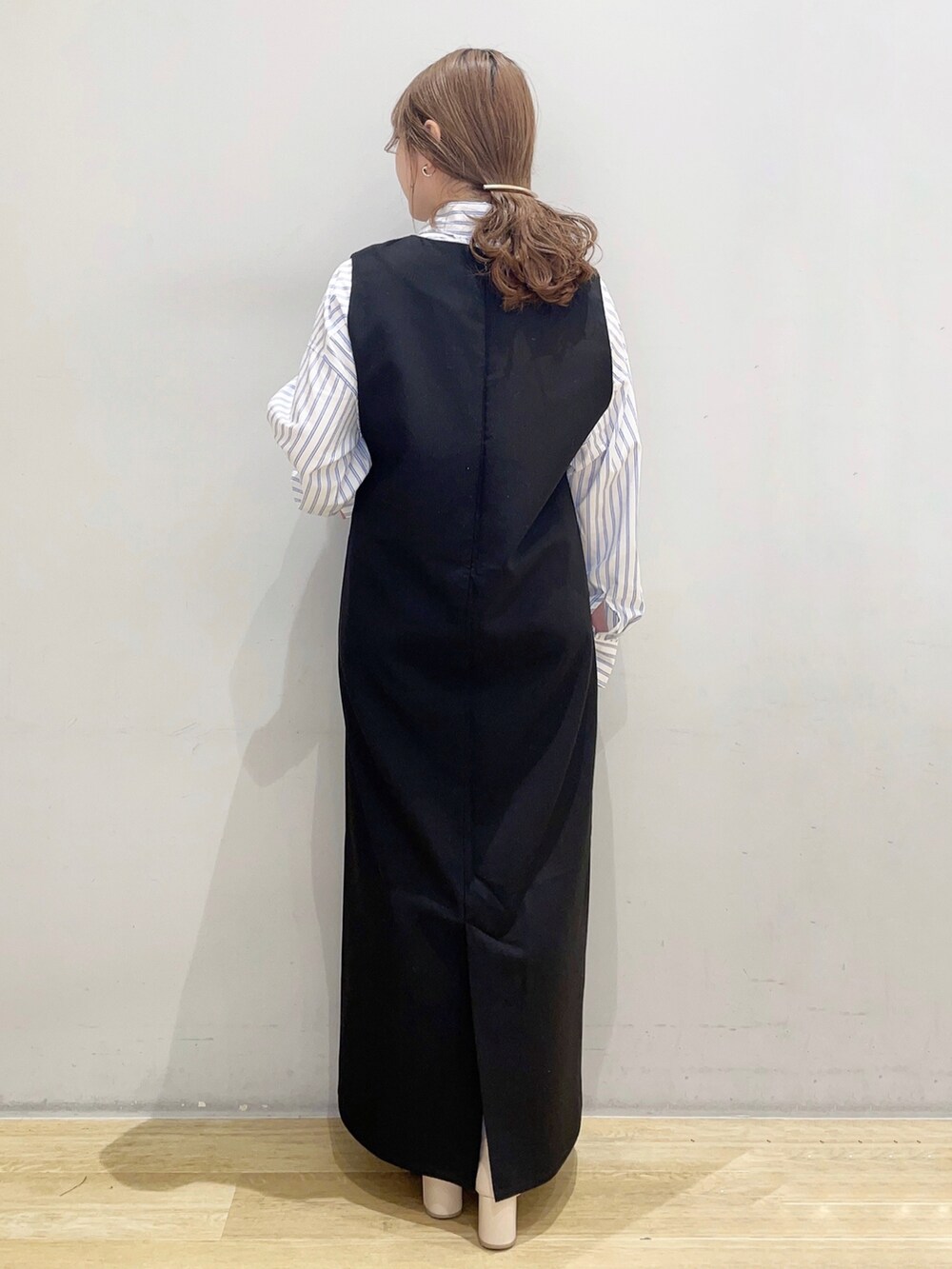 ホワイト系のシャツ/ブラウス、ブラック系のジャンパースカートを着用したレディースの冬コーディネートの2枚目の写真