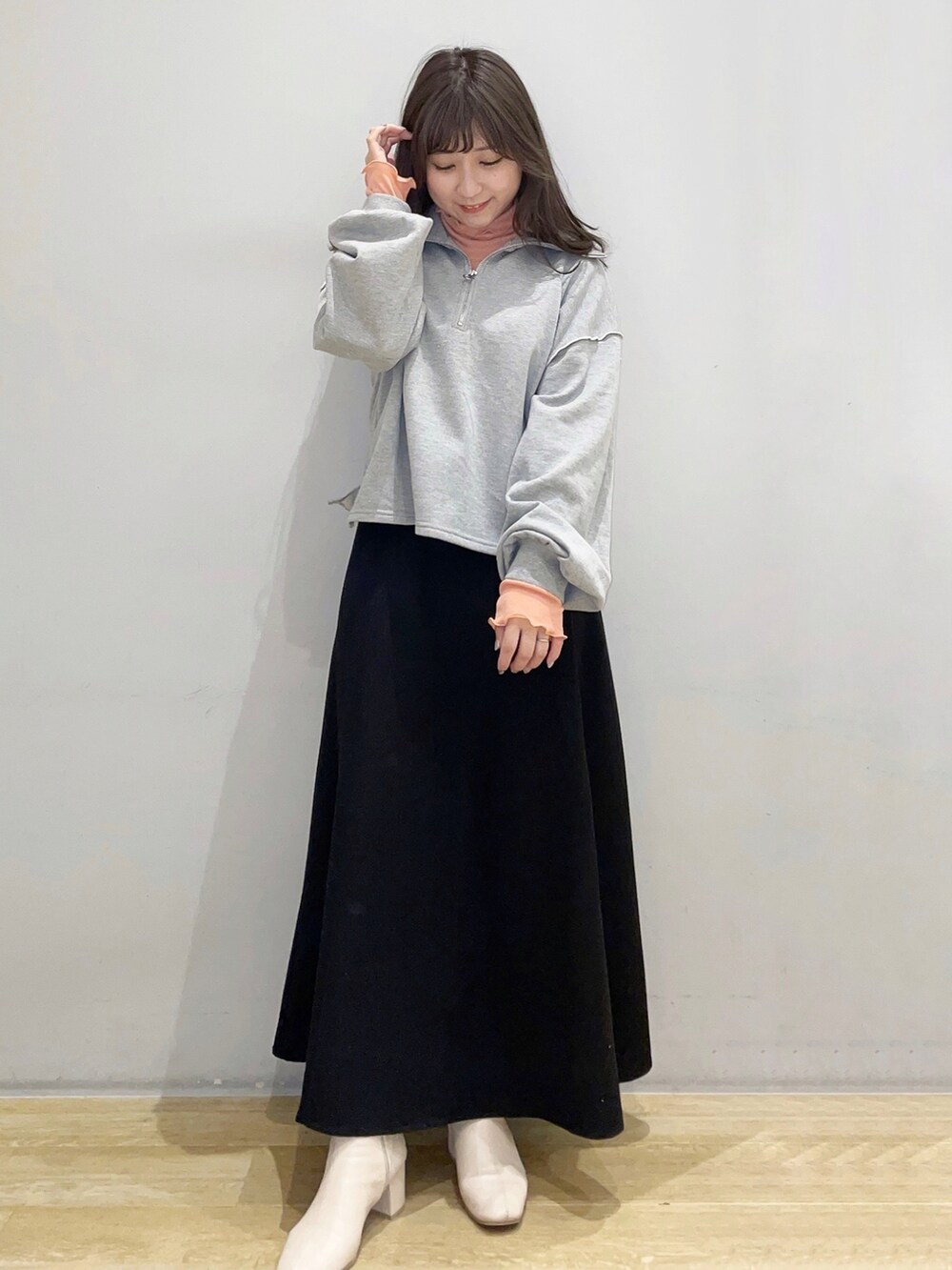 グレー系のTシャツ/カットソー、オレンジ系のその他トップス、ブラック系のスカートを着用したレディースの冬コーディネートの2枚目の写真
