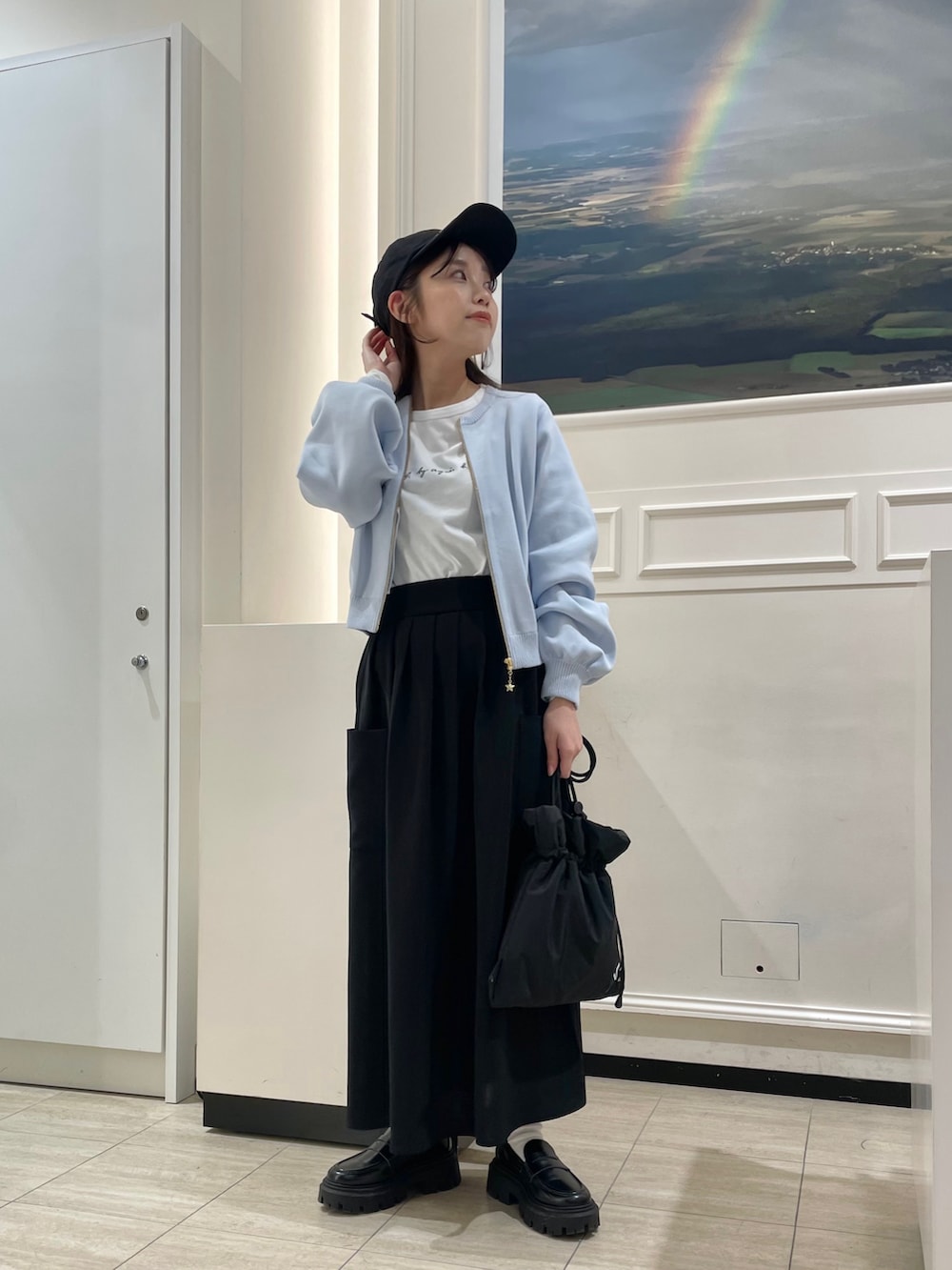 ブラック系のトートバッグ、ホワイト系のTシャツ/カットソー、ブラック系のスカートを着用したレディースの春コーディネートの2枚目の写真