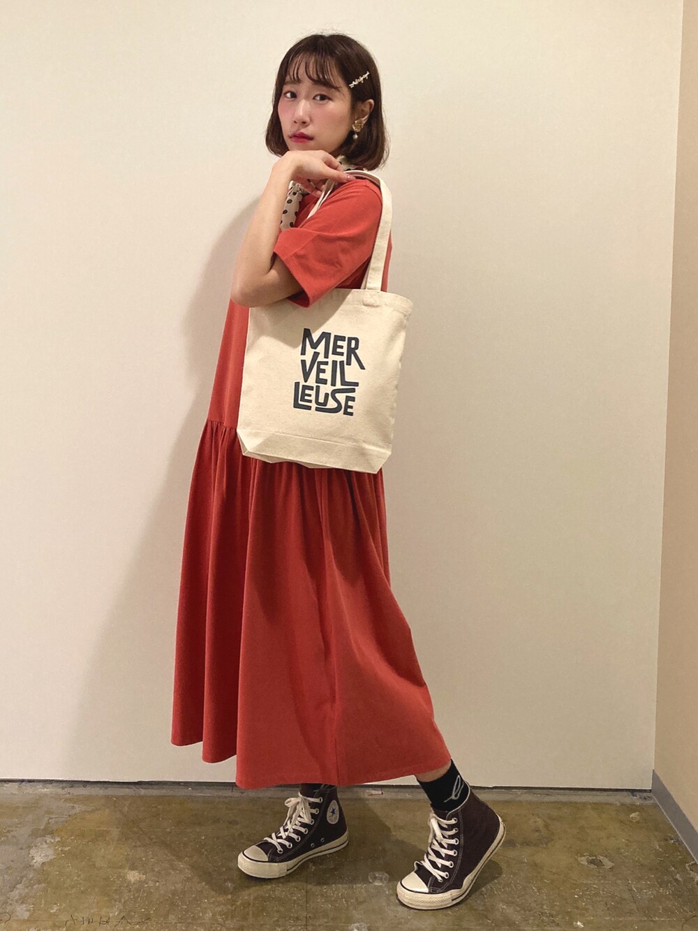 ブルー系のトートバッグ、レッド系のワンピース、ゴールド系のヘアピンを着用したレディースの春コーディネートの2枚目の写真