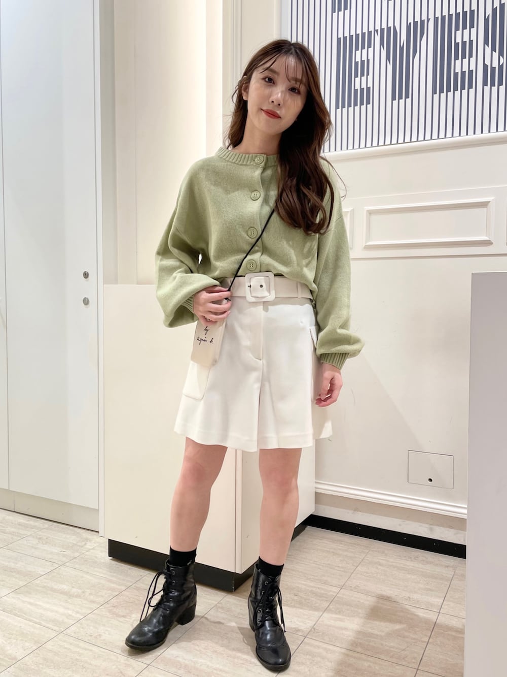 グリーン系のカーディガン/ボレロ、ホワイト系のその他パンツ、ホワイト系のエコバッグ/サブバッグを着用したレディースの秋コーディネートの2枚目の写真