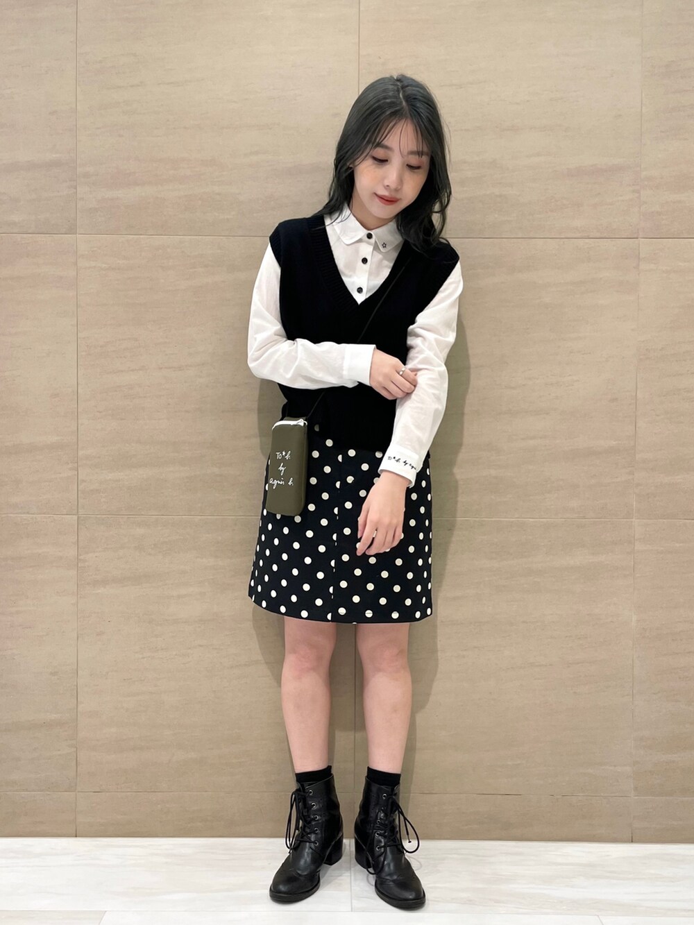 グリーン系のバックパック/リュック、ホワイト系のシャツ/ブラウス、ブラック系のベストを着用したレディースの夏コーディネートの2枚目の写真