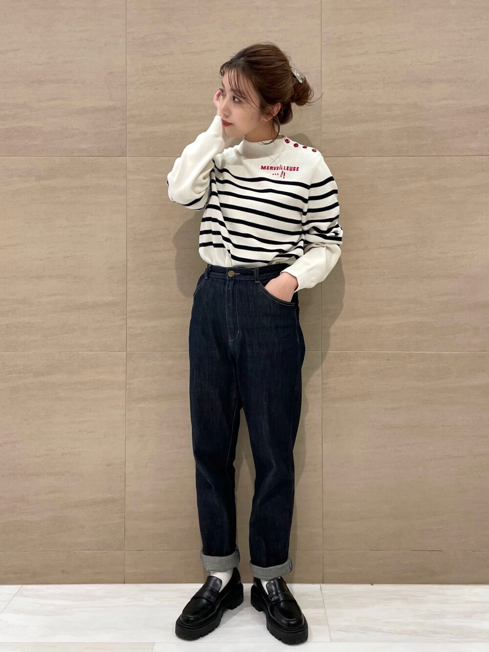 ブルー系のデニムパンツ、ホワイト系のニット/セーターを着用したレディースの秋コーディネートの2枚目の写真