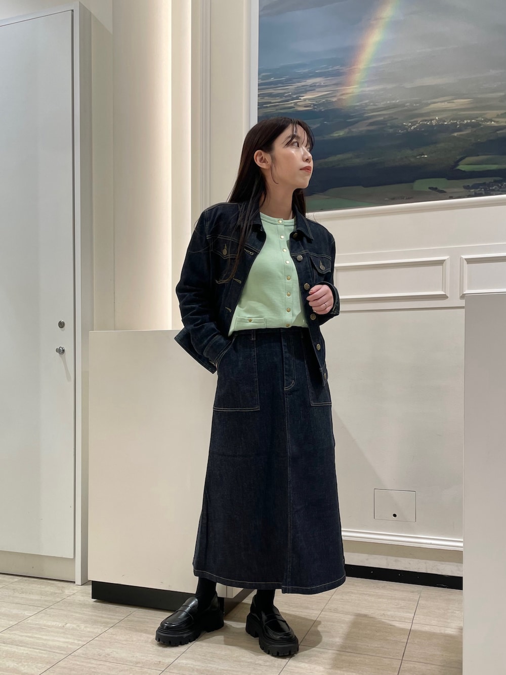 グリーン系のカーディガン/ボレロ、ブルー系のデニムジャケット、ブルー系のスカートを着用したレディースの春コーディネートの2枚目の写真