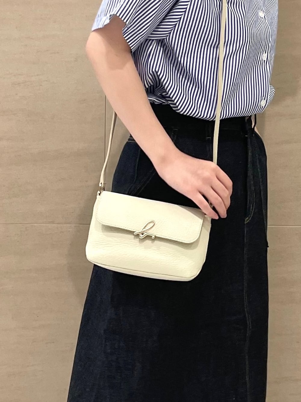 ブルー系のシャツ/ブラウス、ブルー系のスカート、ホワイト系のショルダーバッグを着用したレディースの夏コーディネートの3枚目の写真
