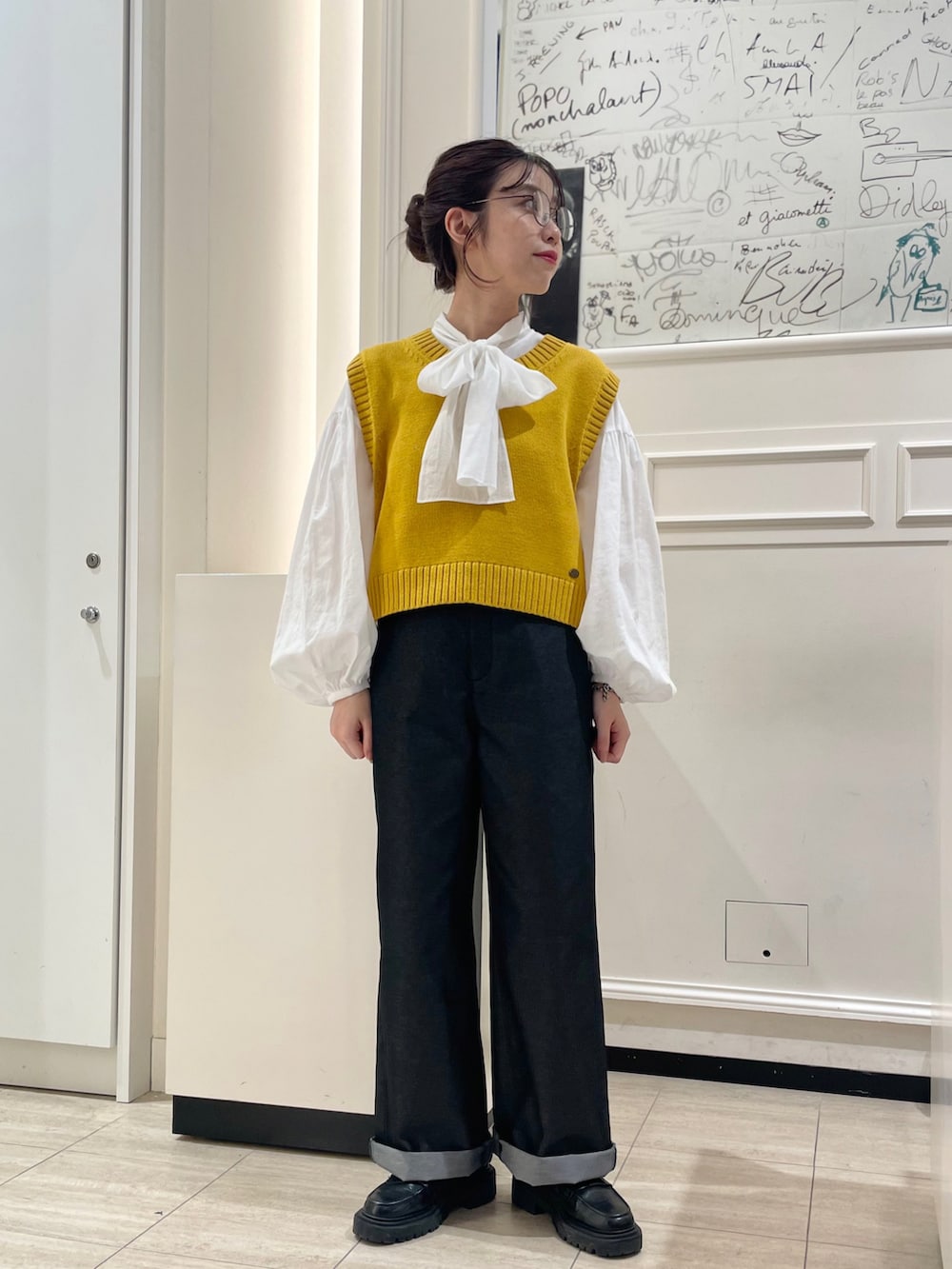 ホワイト系のシャツ/ブラウス、イエロー系のベスト、ブラック系のその他パンツを着用したレディースの秋コーディネートの2枚目の写真