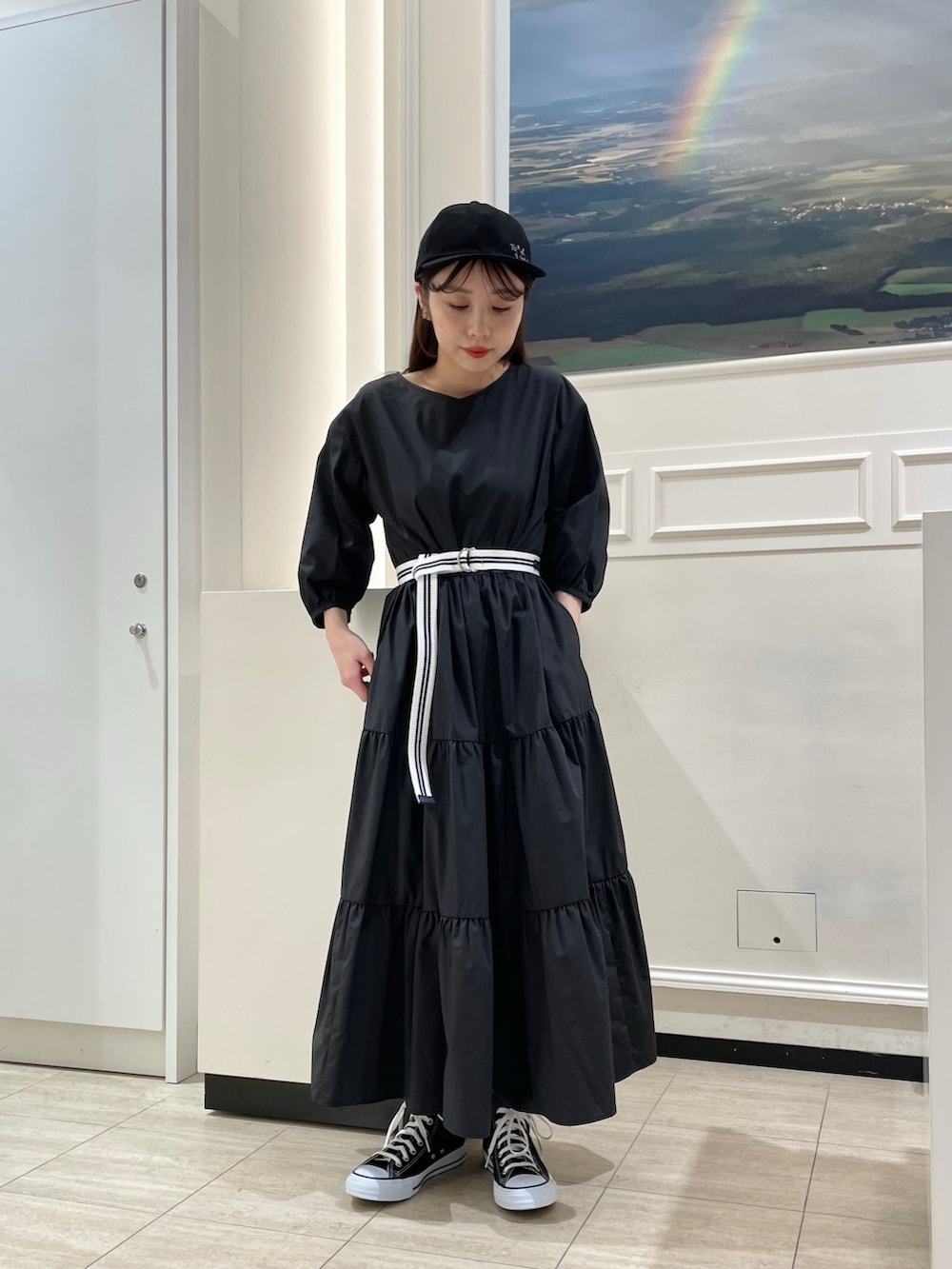 ブラック系のワンピース、ホワイト系のパーカー、ブルー系のベルトを着用したレディースの春コーディネートの2枚目の写真