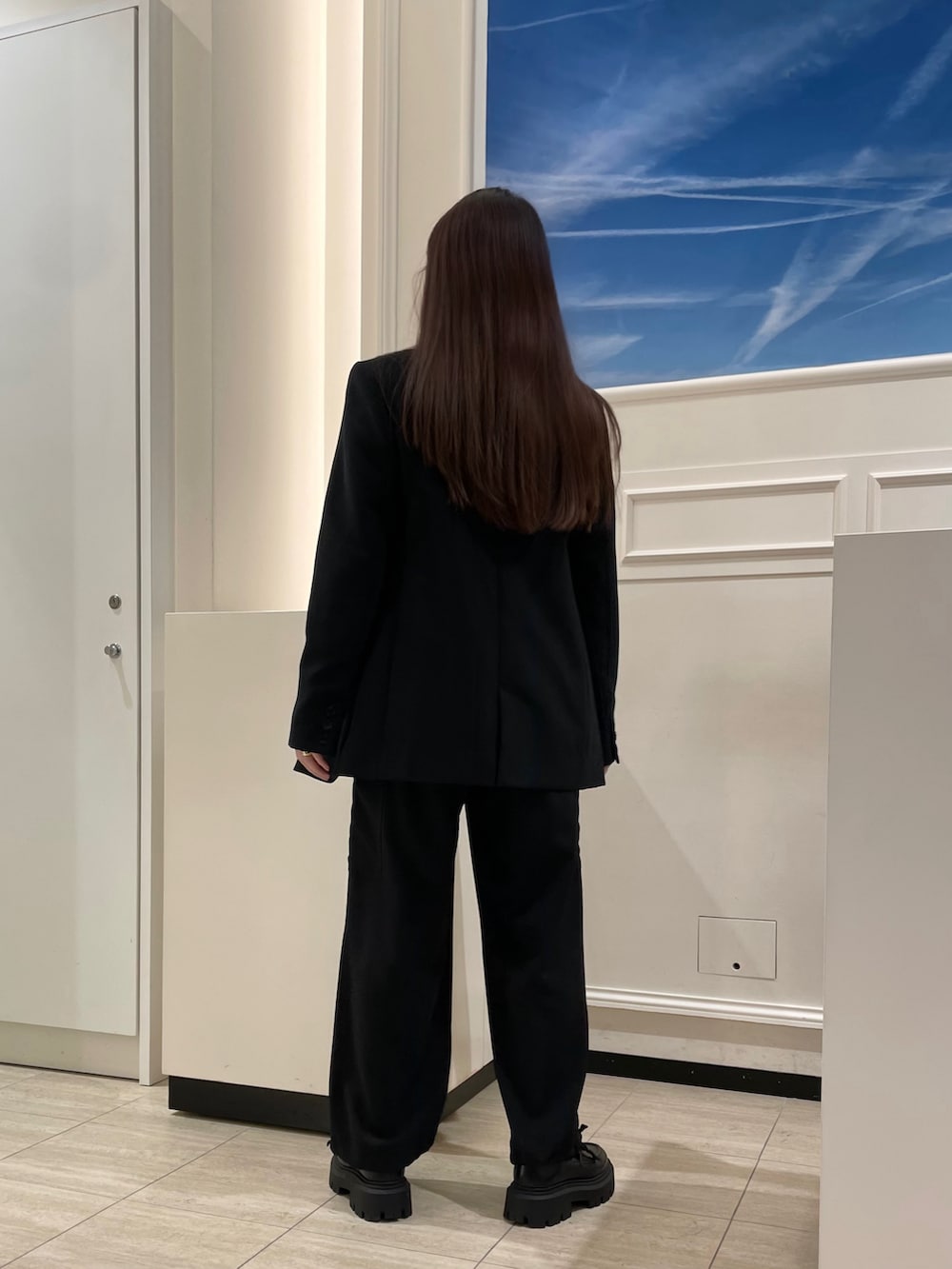 ブラック系のその他パンツ、ホワイト系のニット/セーター、ブラック系のテーラードジャケットを着用したレディースの冬コーディネートの2枚目の写真