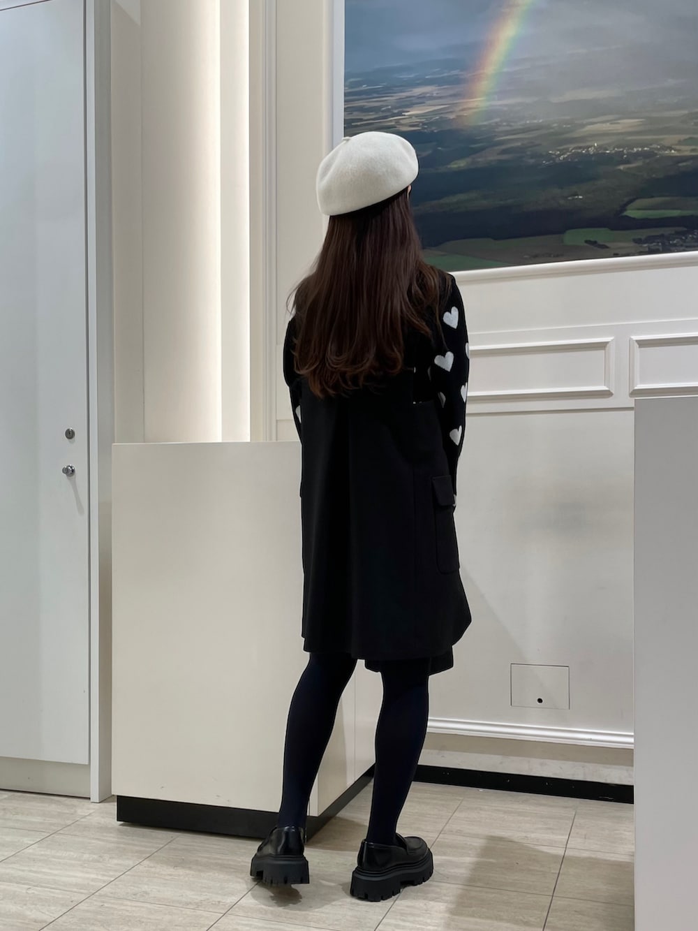 ブラック系のニット/セーター、ブラック系のジャンパースカート、ブラック系のエコバッグ/サブバッグを着用したレディースの冬コーディネートの3枚目の写真