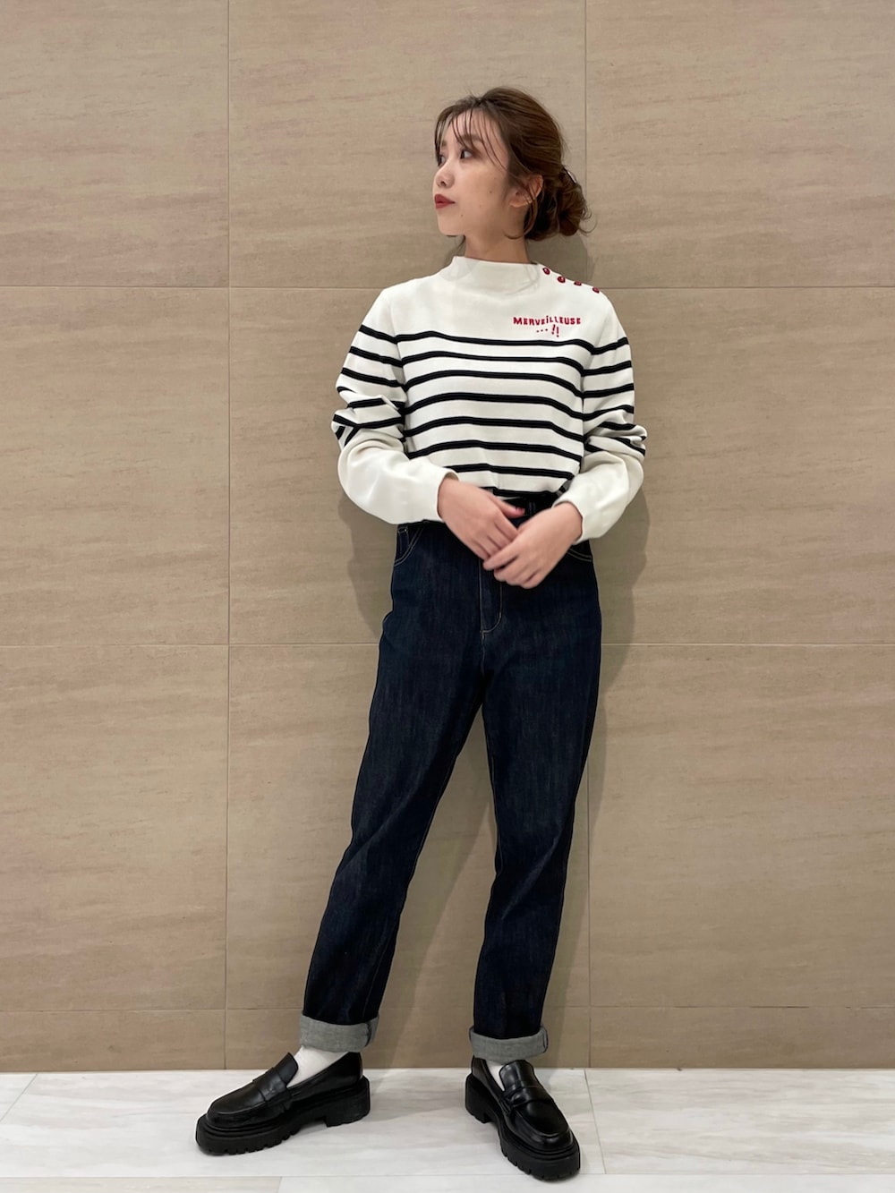 ブルー系のデニムパンツ、ホワイト系のニット/セーターを着用したレディースの秋コーディネートの3枚目の写真