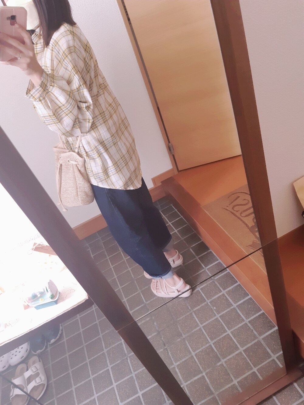 ホワイト系のタンクトップ、ブルー系のデニムパンツ、ベージュ系のサンダルを着用したレディースの夏コーディネートの2枚目の写真