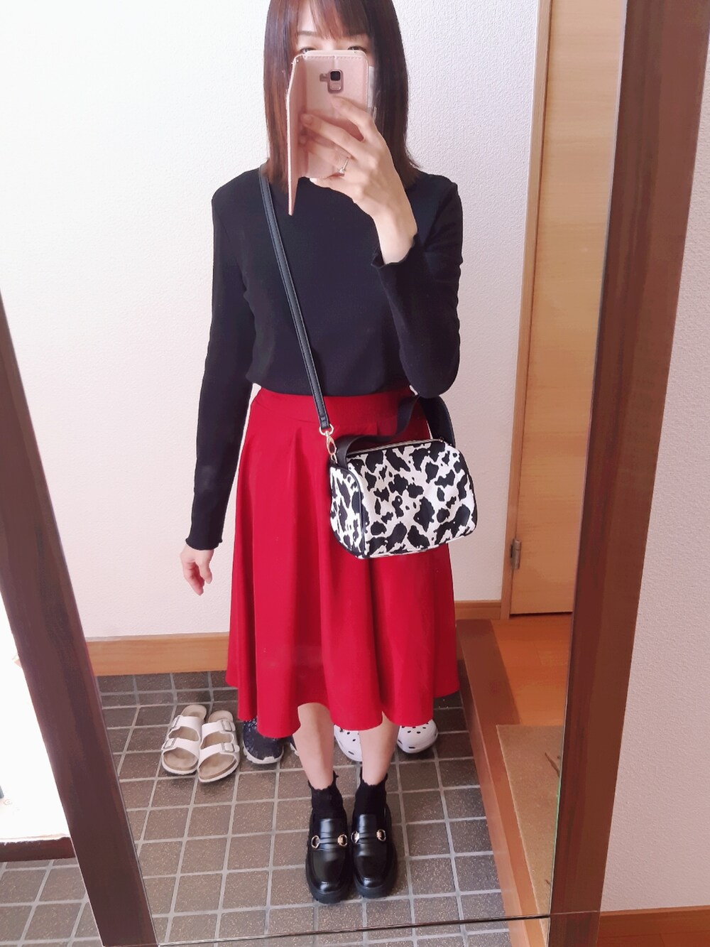 レッド系のスカート、ブラック系のローファー、ホワイト系のショルダーバッグを着用したレディースの春コーディネートの3枚目の写真