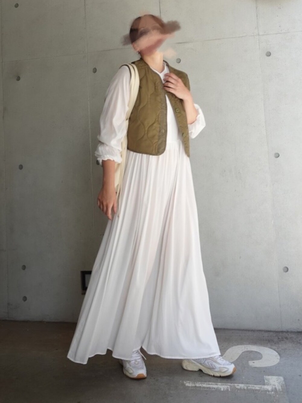 ホワイト系のシャツワンピース、グリーン系のベスト、ホワイト系のスニーカーを着用したレディースの秋コーディネートの2枚目の写真