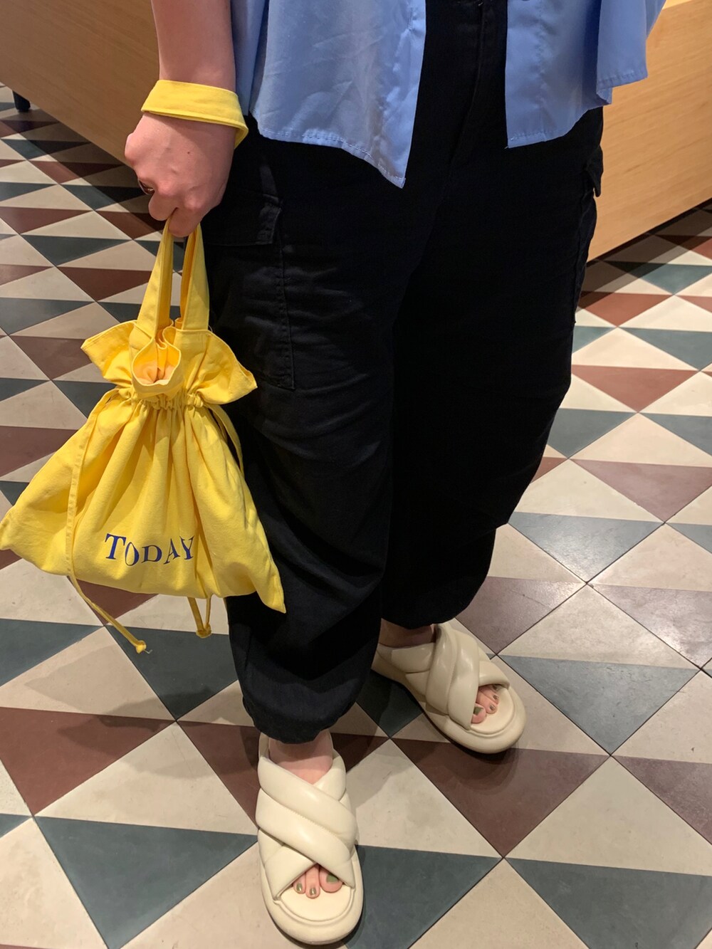 ブルー系のシャツ/ブラウス、ブラック系のカーゴパンツ、イエロー系のトートバッグを着用したレディースの夏コーディネートの3枚目の写真