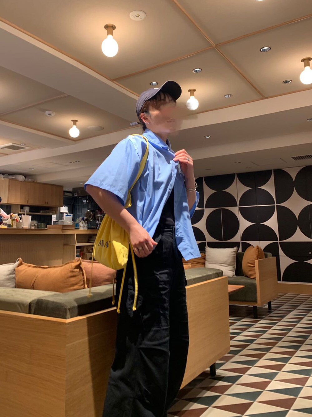 ブルー系のシャツ/ブラウス、ブラック系のカーゴパンツ、イエロー系のトートバッグを着用したレディースの夏コーディネートの2枚目の写真