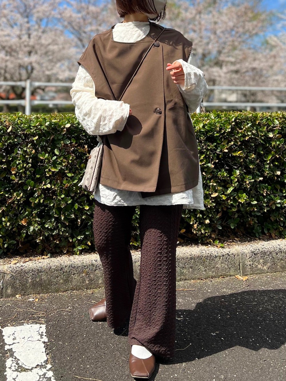 ホワイト系のTシャツ/カットソー、その他のショルダーバッグ、ブラウン系のパンツを着用したレディースの春コーディネートの2枚目の写真