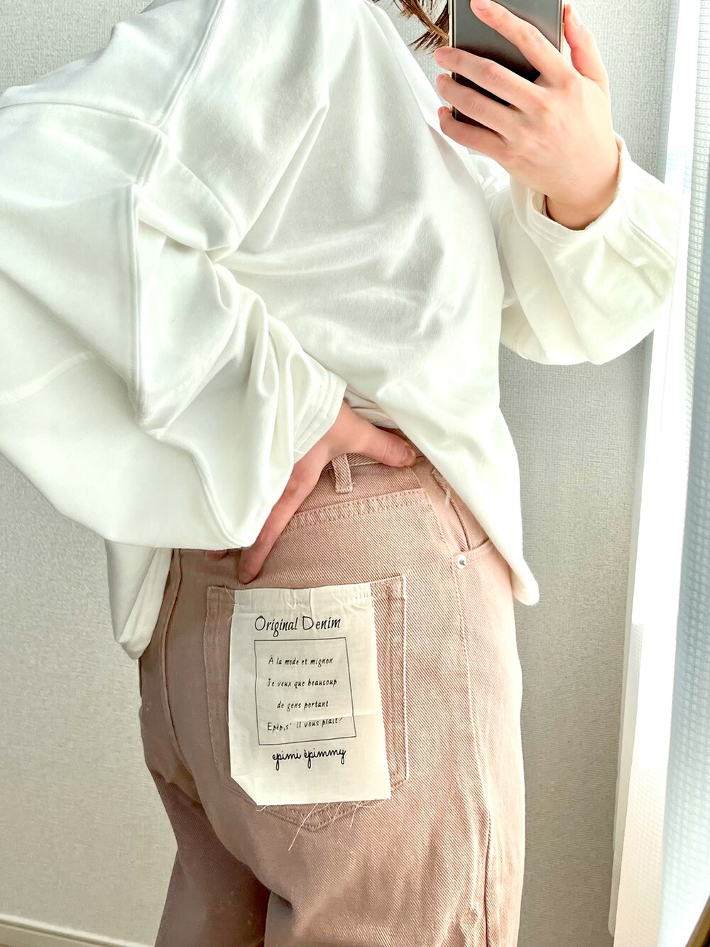 ピンク系のデニムパンツ、ベージュ系のベスト、ホワイト系のTシャツ/カットソーを着用したレディースの春コーディネートの2枚目の写真