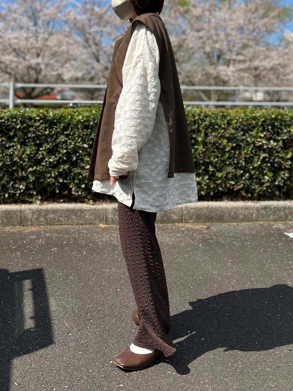 ホワイト系のTシャツ/カットソー、その他のショルダーバッグ、ブラウン系のパンツを着用したレディースの春コーディネートの3枚目の写真