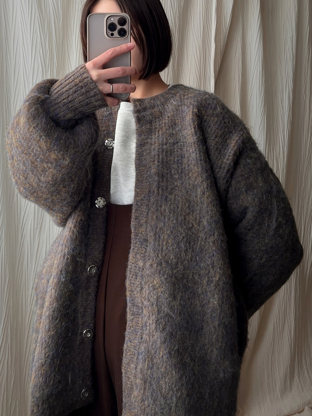 ブラウン系のノーカラーコート、ブラウン系のサロペット/オーバーオール、ベージュ系のスニーカーを着用したレディースの冬コーディネートの2枚目の写真