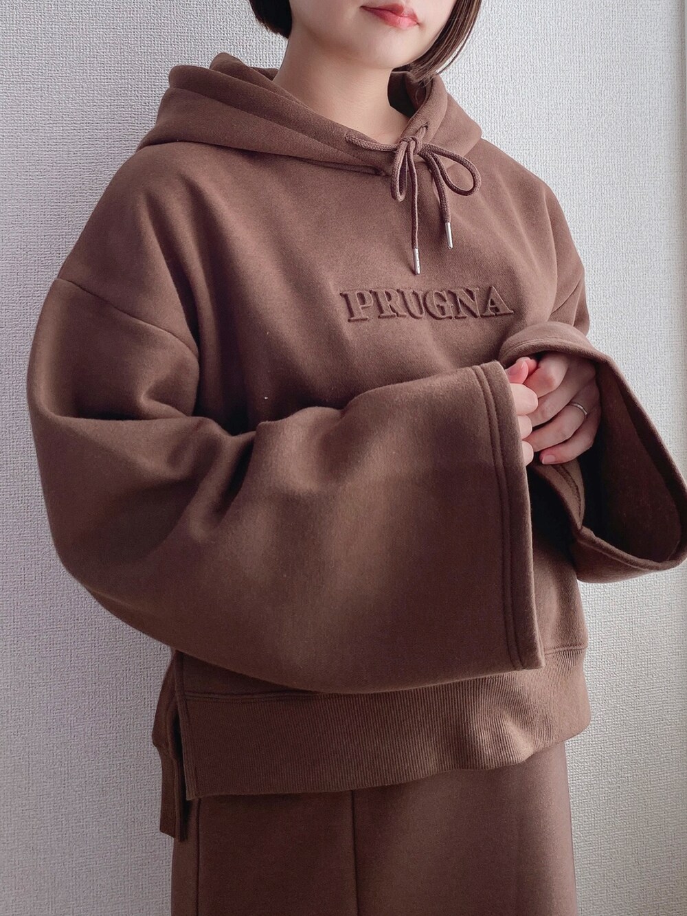 ブラウン系のパーカー、ブラウン系のスカート、ブラック系のローファーを着用したレディースの冬コーディネートの3枚目の写真