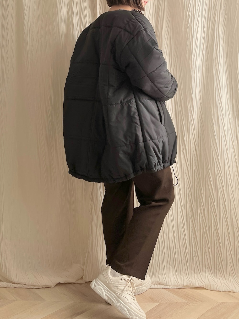 ブラック系のダウンジャケット/コート、その他のショルダーバッグ、ブラウン系のスラックスを着用したレディースの冬コーディネートの2枚目の写真