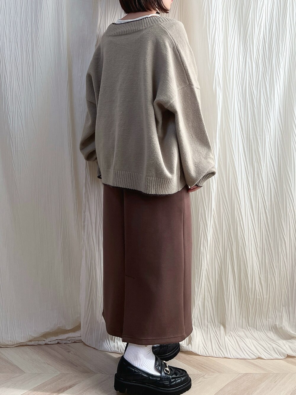 ベージュ系のカーディガン/ボレロ、ブラウン系のスカート、ブラック系のローファーを着用したレディースの秋コーディネートの3枚目の写真