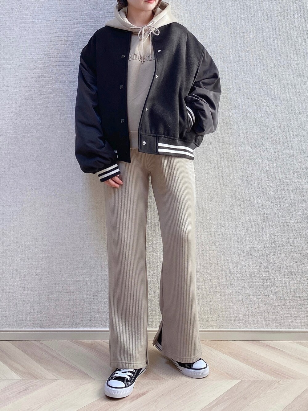 ブラック系のスタジャン、ベージュ系のその他パンツ、ブラック系のスニーカーを着用したレディースの秋コーディネートの2枚目の写真
