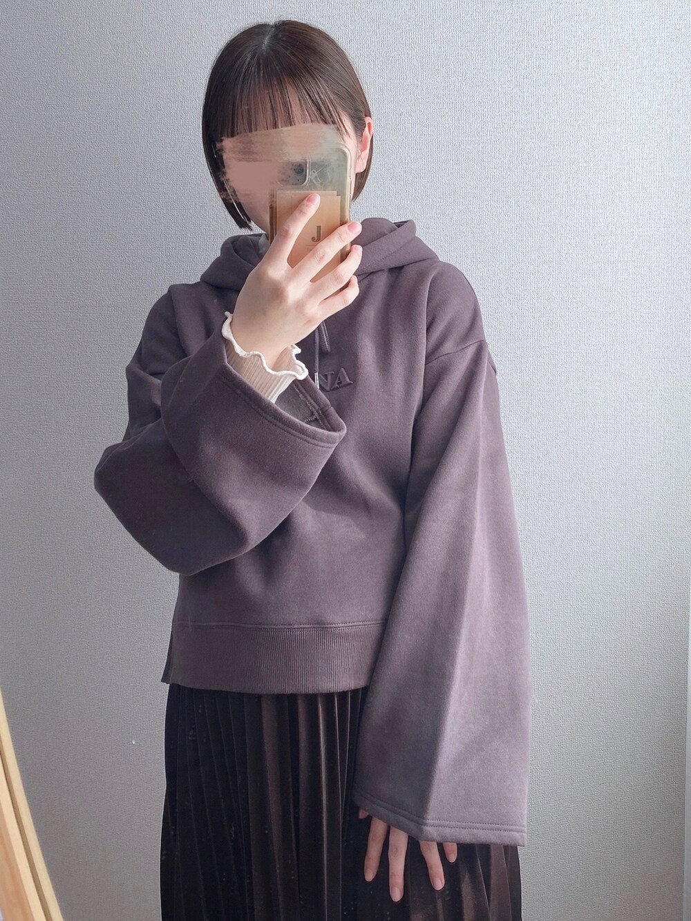 ブラック系のパーカー、ブラウン系のスカート、ブラック系のその他シューズを着用したレディースの冬コーディネートの2枚目の写真