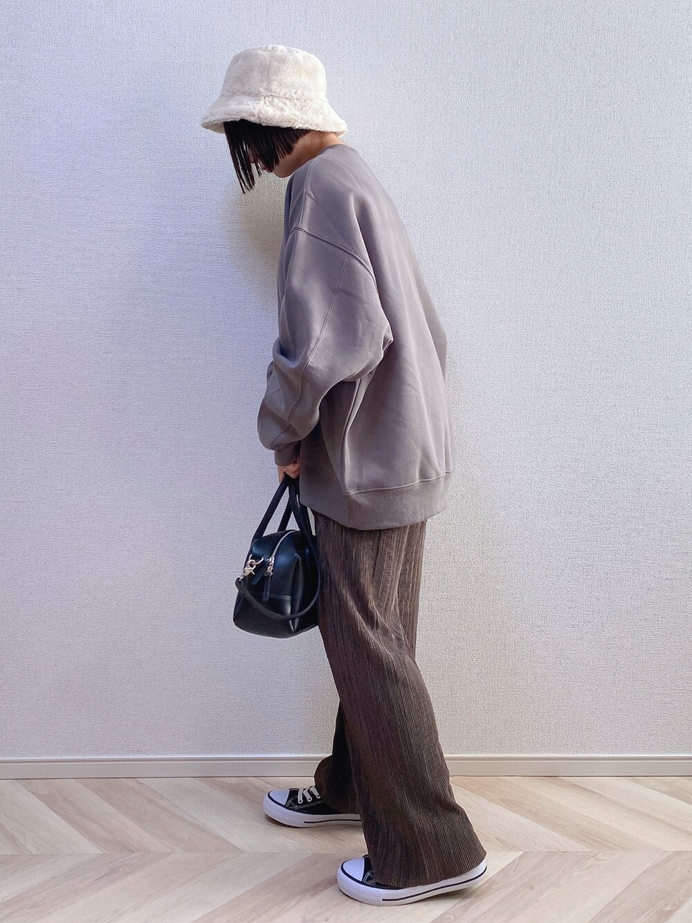 ブラウン系のスウェット、ブラック系のボストンバッグ、ブラウン系のパンツを着用したレディースの秋コーディネートの3枚目の写真