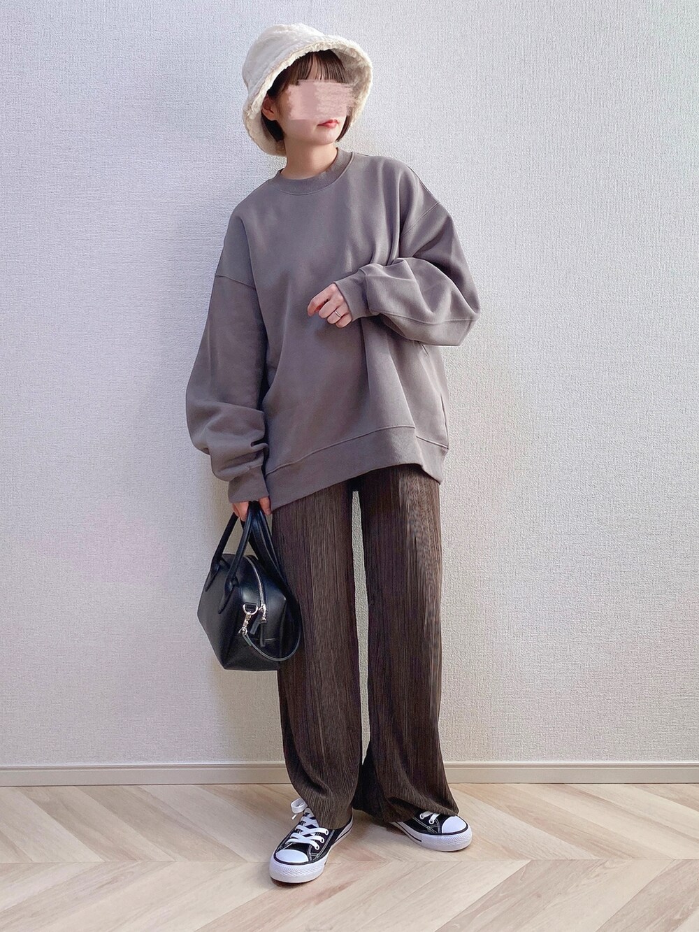 ブラウン系のスウェット、ブラック系のボストンバッグ、ブラウン系のパンツを着用したレディースの秋コーディネートの2枚目の写真