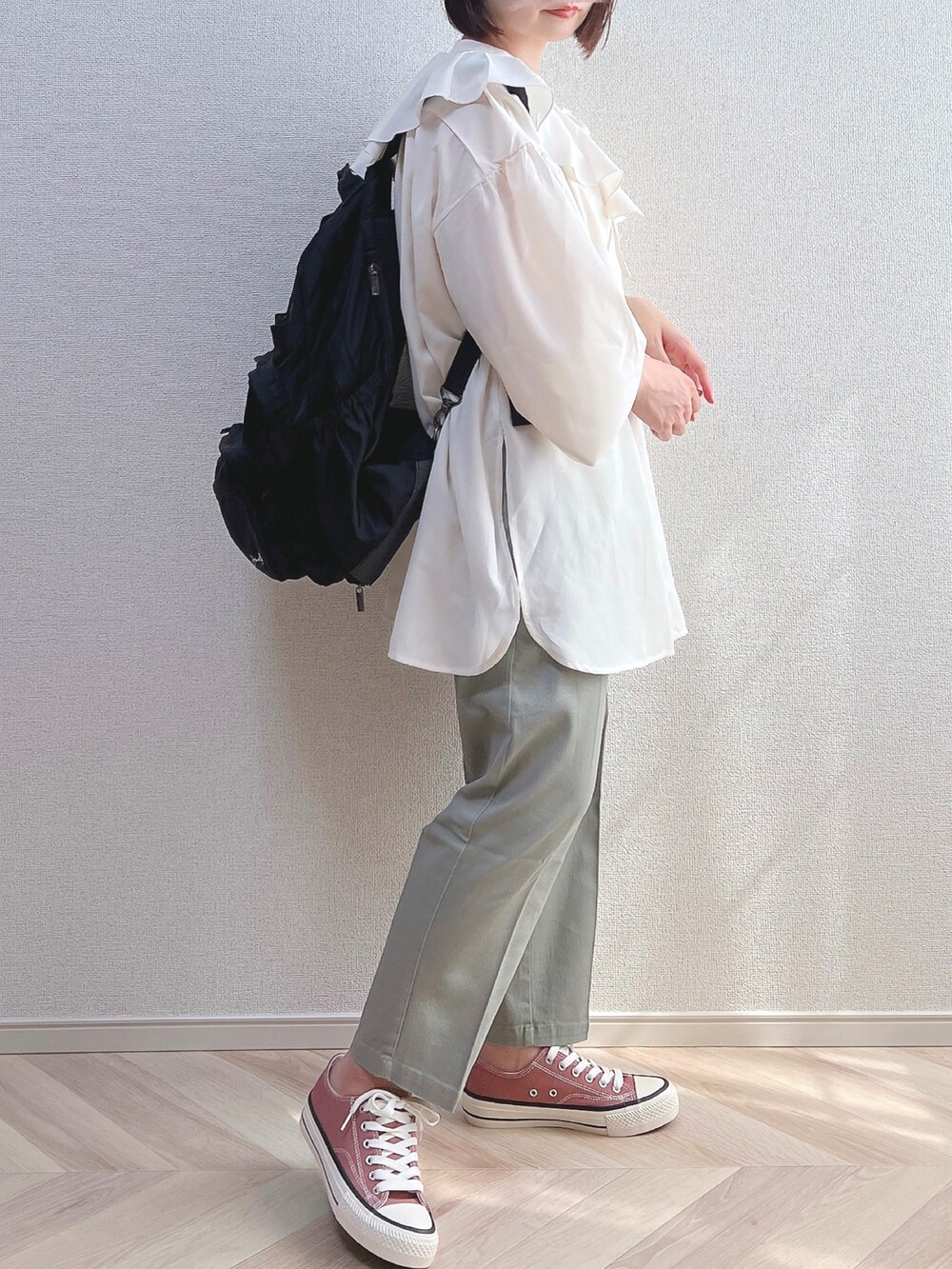 ベージュ系のシャツ/ブラウス、ブラック系のバックパック/リュック、ホワイト系のトップスを着用したレディースの夏コーディネートの2枚目の写真