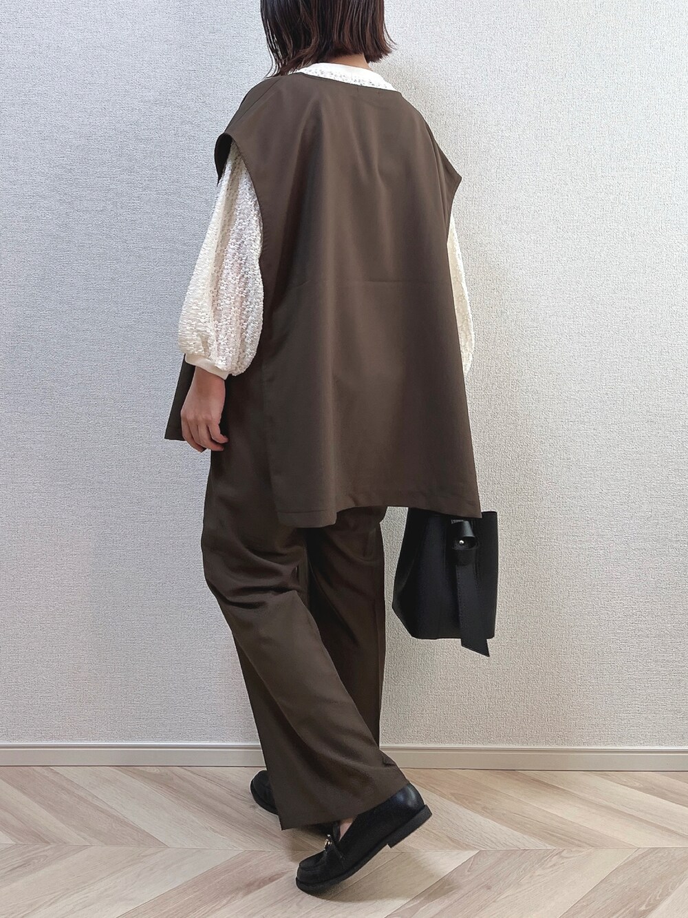 ホワイト系のTシャツ/カットソー、ブラウン系のパンツ、ブラック系のローファーを着用したレディースの秋コーディネートの2枚目の写真