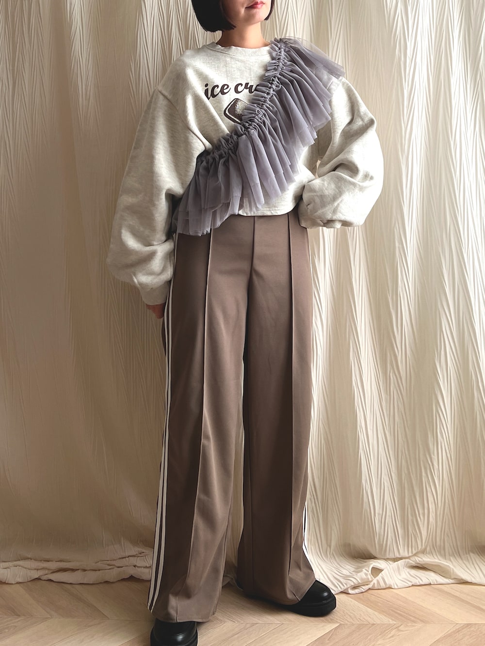 ホワイト系のスウェット、ブラウン系のパンツ、グレー系の付け襟を着用したレディースの冬コーディネートの2枚目の写真