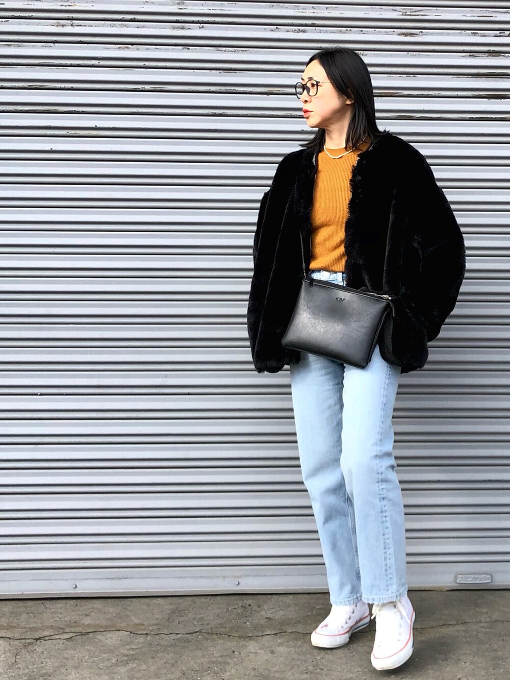 ブラック系のジャケット/アウター、ブルー系のデニムパンツを着用したレディースの冬コーディネートの2枚目の写真