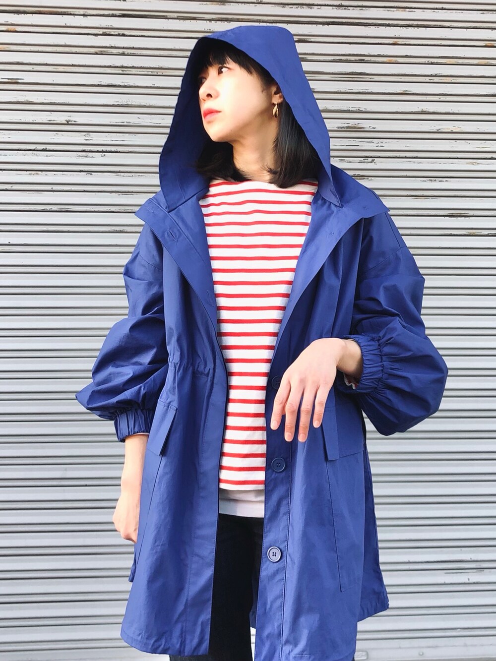 ブルー系のマウンテンパーカーを着用したレディースの春コーディネートの2枚目の写真